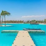 Tropisch zwembad met volleyballveld en uitzicht op resorts
