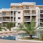 3D-weergave van luxe resort met zwembad en ligstoelen bij zonsondergang