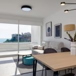 Keukeninterieur met barstoelen, houtafwerking, moderne apparaten en witte oppervlakken