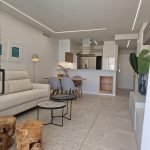 Moderne woonkamer met zithoek en open keuken in neutrale tonen