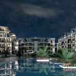 Nachtbeeld van verlicht appartementencomplex met zwembad