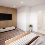 Ruime slaapkamer met houten wandpaneel televisie en toegang tot badkamer
