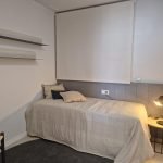 Sfeervolle slaapkamer met enkel bed en decoratieve kussens