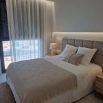 Slaapkamerinterieur met tweepersoonsbed en grote ramen