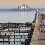 Panoramische zicht op lange promenade langs kust met fietsers en voetgangers