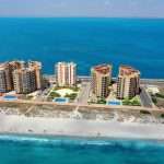Luchtfoto van strand met gebouwen en blauwe zee